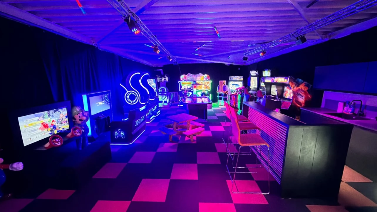 Overzicht van de gamehal in GameLounge Leusden met arcadegames en verlichting
