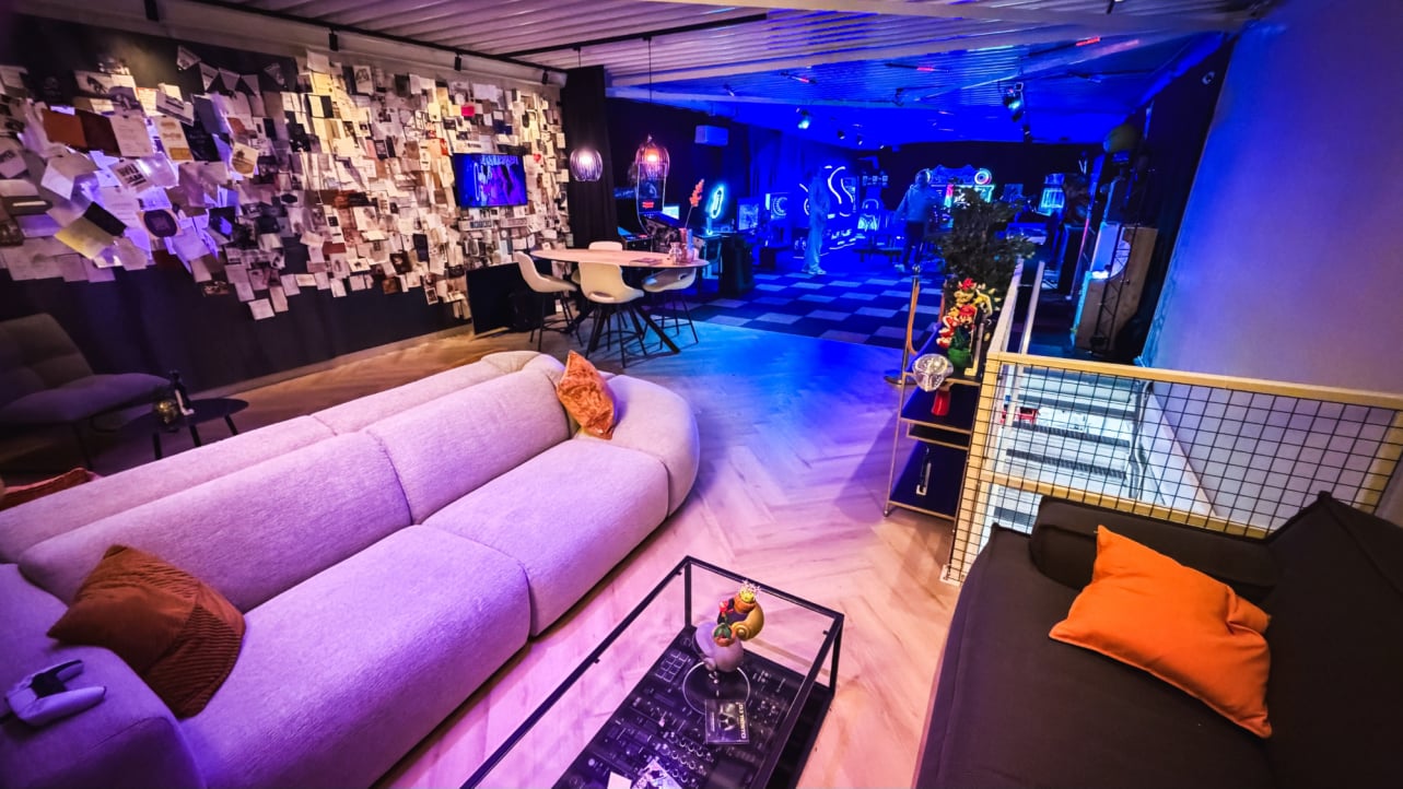 Lounge met zithoeken, statafels en sfeervolle verlichting in GameLounge Leusden